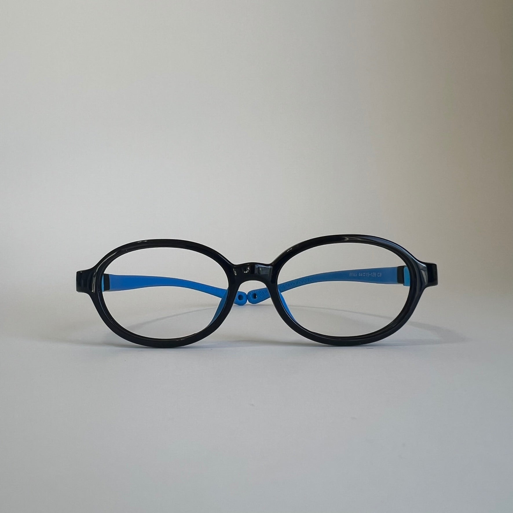 PureFlex oval kids flexible glasses in black and blue silicone material, showcasing the lightweight frame and flexible temple arms for children.
