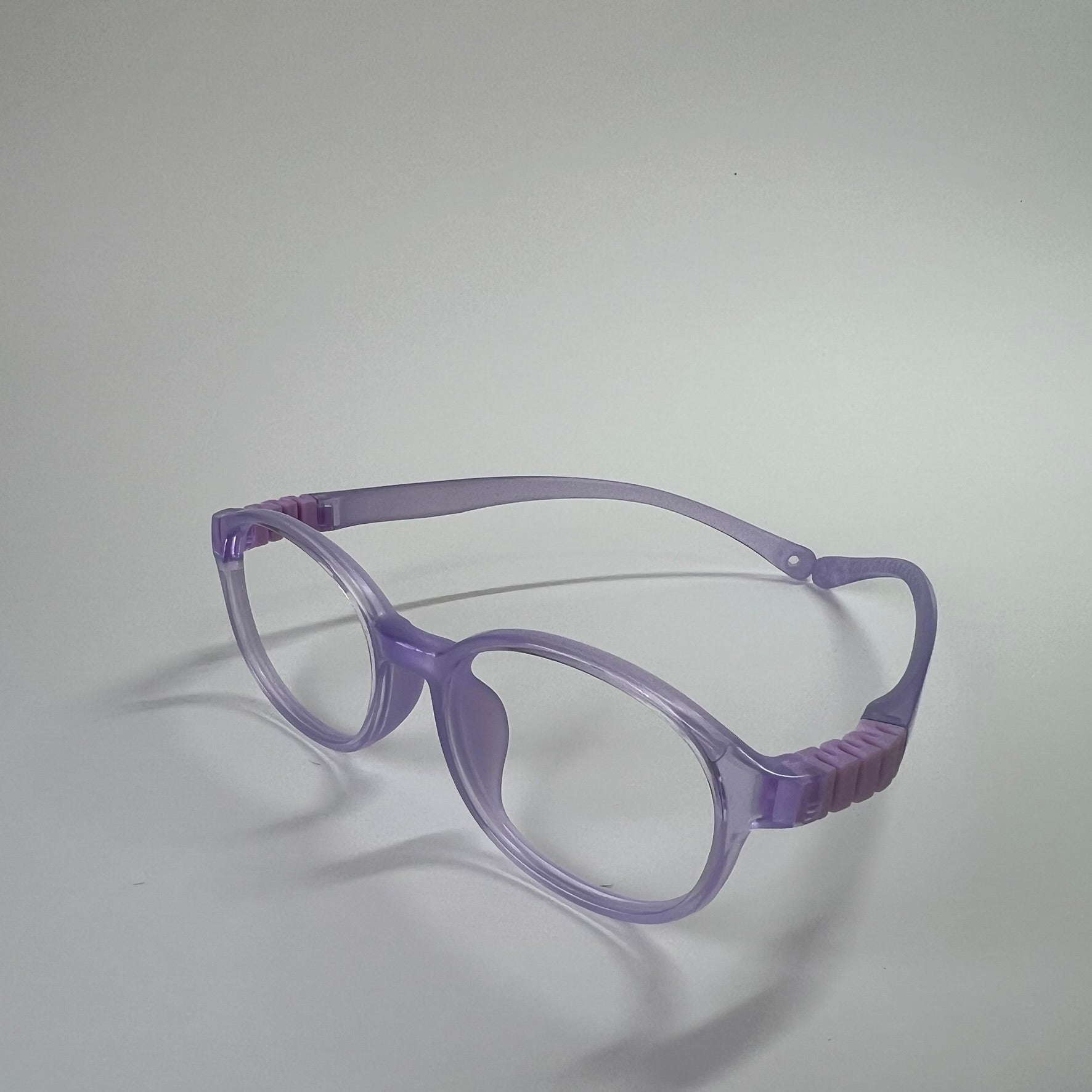 PureFlex kids flexible glasses in translucent jelly purple silicone material, showcasing the specialized wrap-around curved temple arms for ages 7-9. Side view.