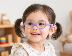 Lenslott purple kids flexible round glasses with a comfort strap, worn by a smiling toddler.