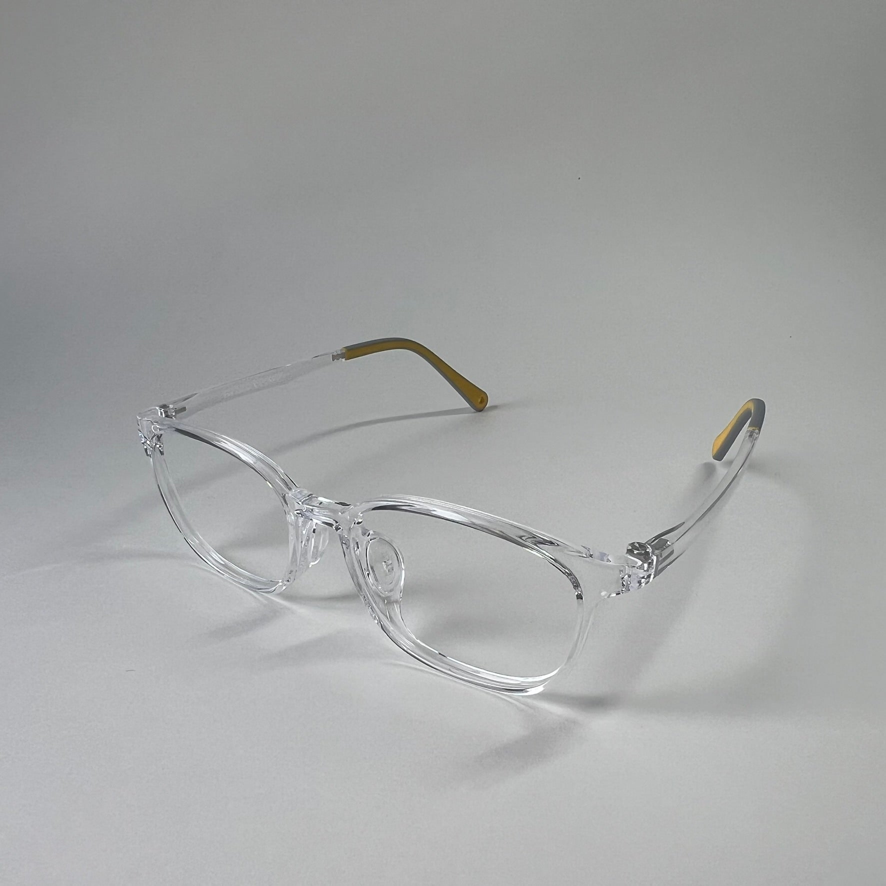 MiniMuse clear transparent rounded square prescription glasses for kids and tweens with silicone nose pads and adjustable temple tips. Side view.
